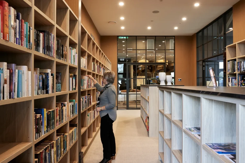 Residents browsing books in the library at Tamahere Country Club