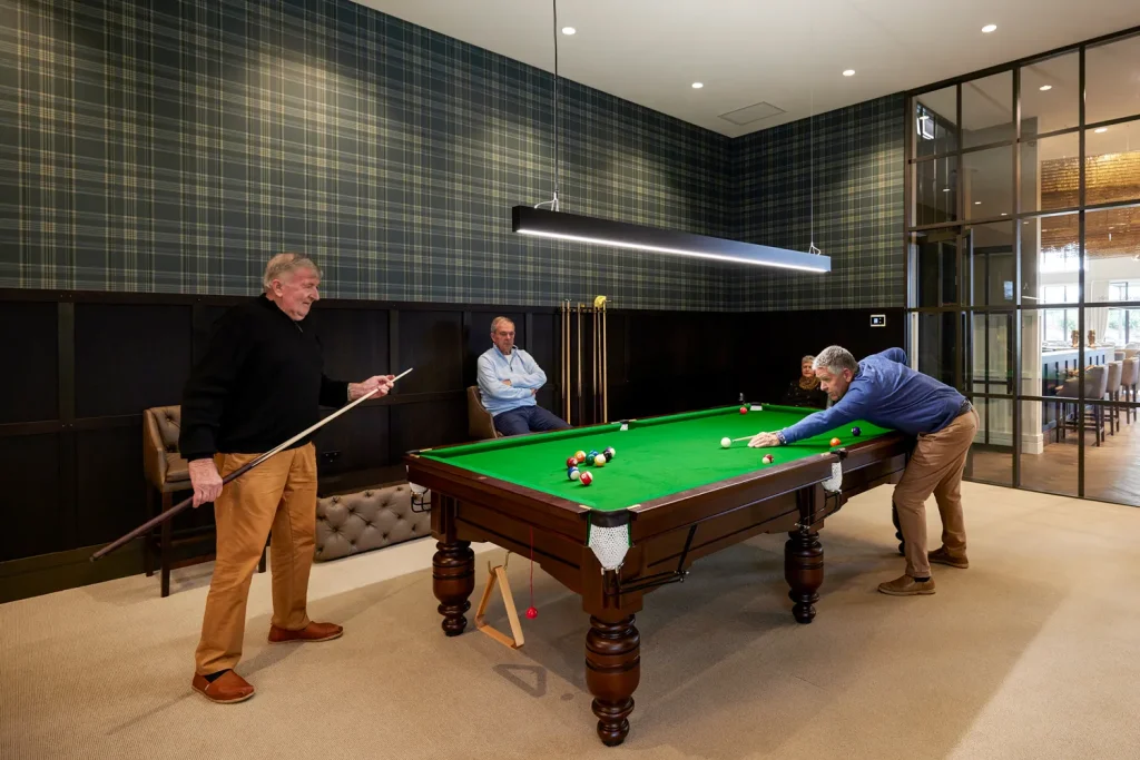 Residents playing snooker on a billiards table at Tamahere Country Club