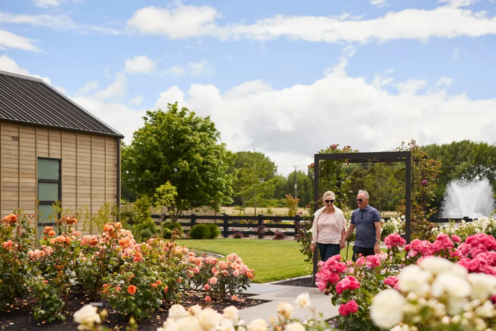 Mature couple walking through rose garden at Tamahere Country Club