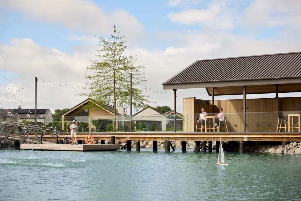 Residents playing with a RC boat at the new lake and Lakehouse Pavilion at Tamahere Country Club