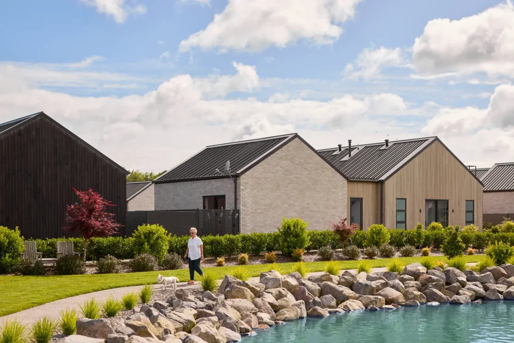 Resident walking her dog around the lake pathways at Tamahere Country Club