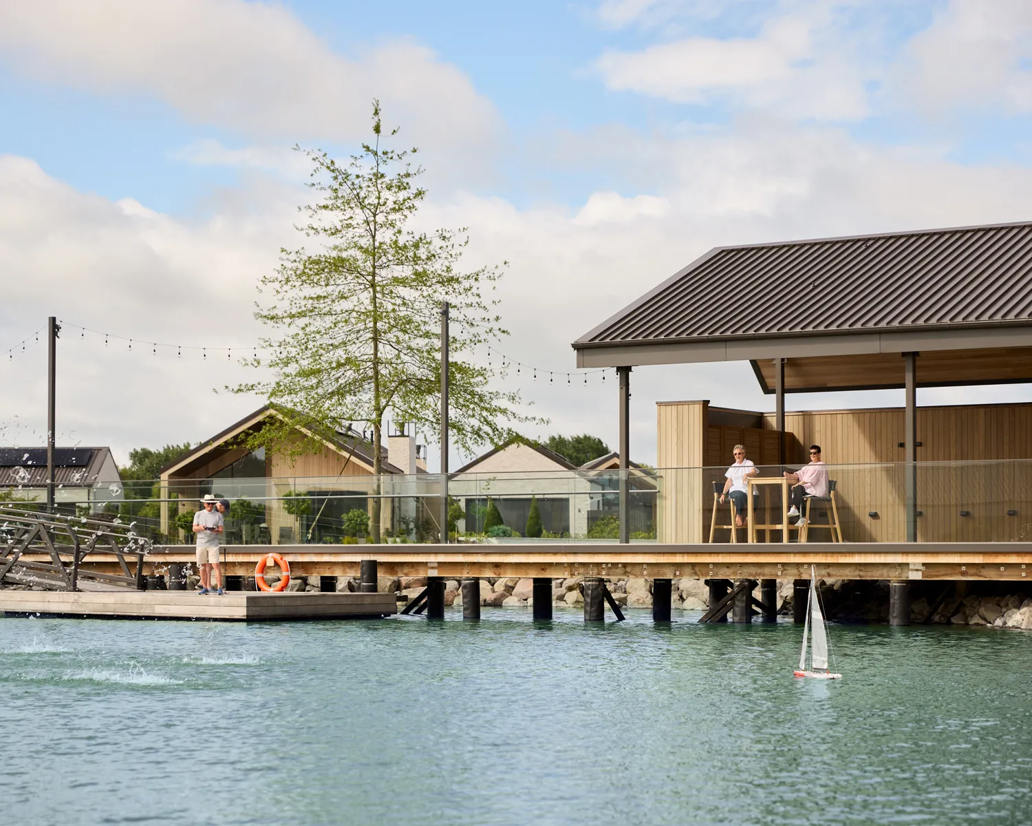 Residents playing with a RC boat at the Lake Pavilion at Tamahere Country Club