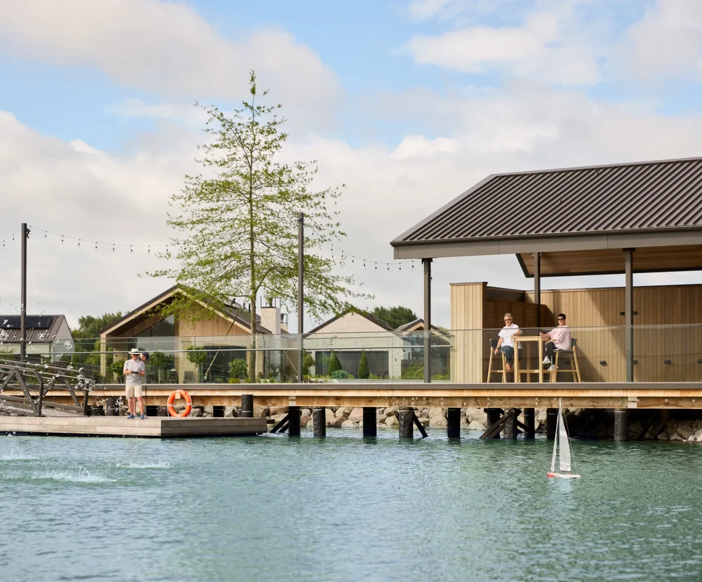 Residents playing with a RC boat at the Lake Pavilion at Tamahere Country Club